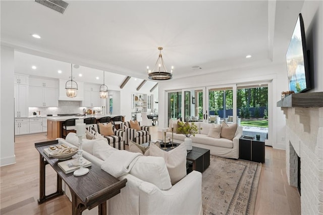 477 Michael Dr, Alpharetta, GA 30009 - living room featuring a chandelier, light wood-style flooring, a brick fireplace, recessed lighting, and vaulted ceiling