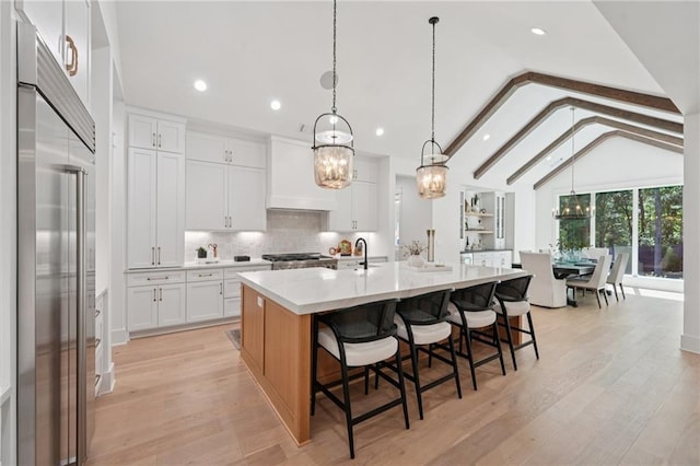 477 Michael Dr, Alpharetta, GA 30009 - kitchen with built in refrigerator, recessed lighting, white cabinetry, backsplash, and a kitchen bar