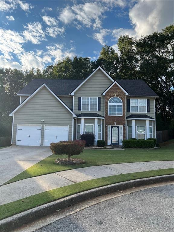 view of front of property with a garage and a front lawn