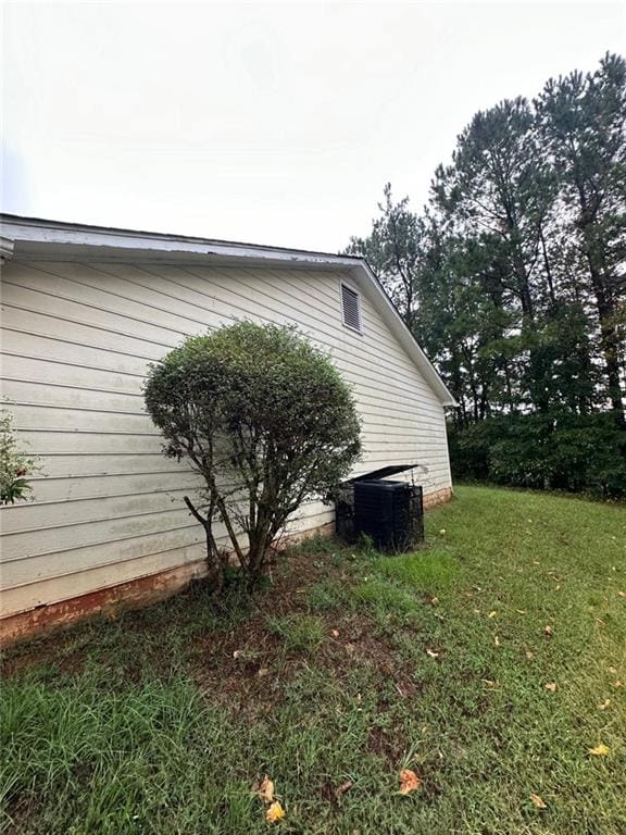 view of home's exterior with a lawn and central air condition unit