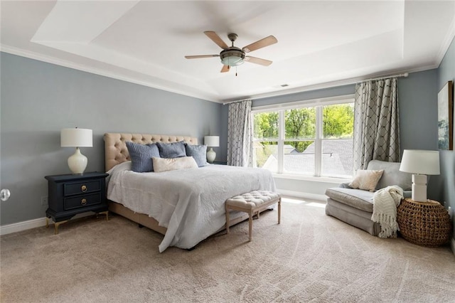 carpeted bedroom with visible vents, ornamental molding, baseboards, ceiling fan, and a raised ceiling