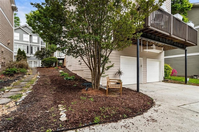 view of property exterior with an attached garage and driveway