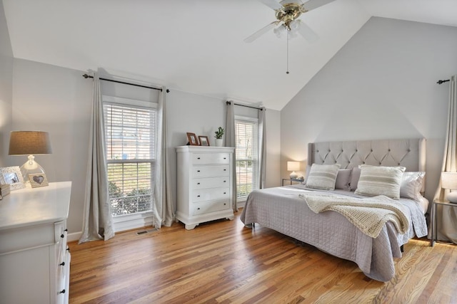 bedroom with visible vents, lofted ceiling, light wood-style floors, and a ceiling fan