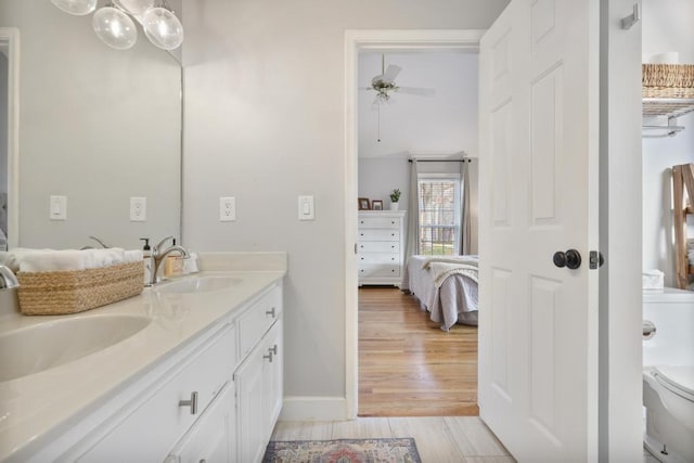 full bath with ensuite bath, wood finished floors, double vanity, and a sink