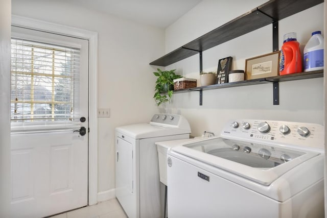 laundry area featuring light tile patterned flooring, washing machine and dryer, and laundry area