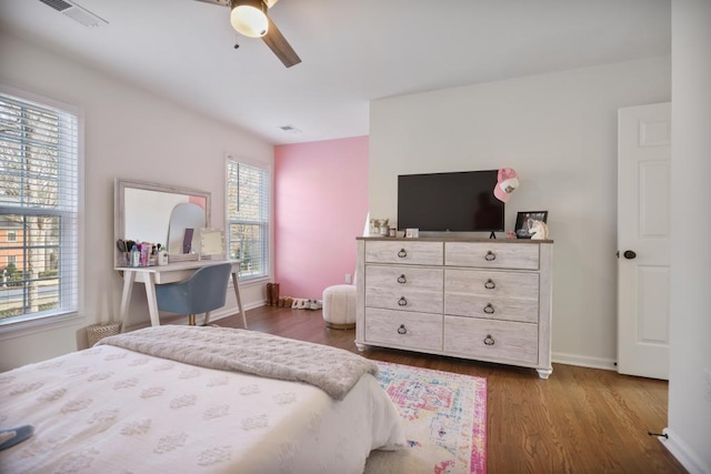 bedroom with dark wood finished floors, baseboards, visible vents, and ceiling fan