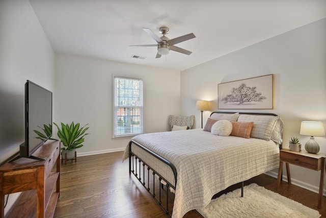 bedroom with visible vents, baseboards, wood finished floors, and a ceiling fan