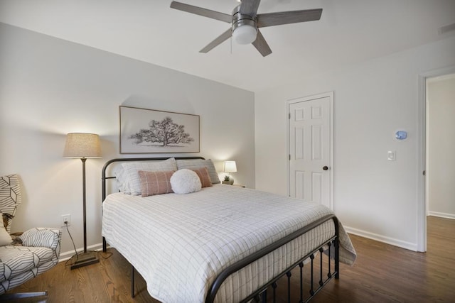 bedroom with visible vents, a ceiling fan, baseboards, and wood finished floors