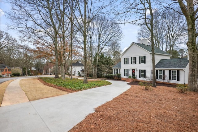 view of front of home featuring roof with shingles and a chimney