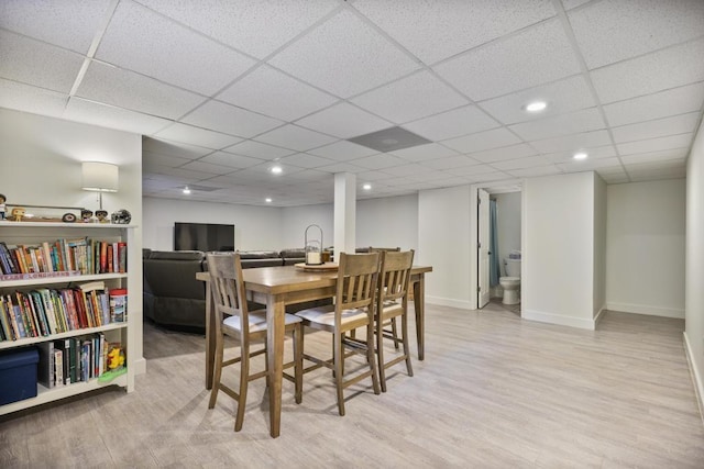 dining area with recessed lighting, baseboards, a paneled ceiling, and light wood-style floors