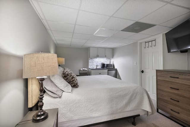 bedroom featuring a paneled ceiling and carpet floors