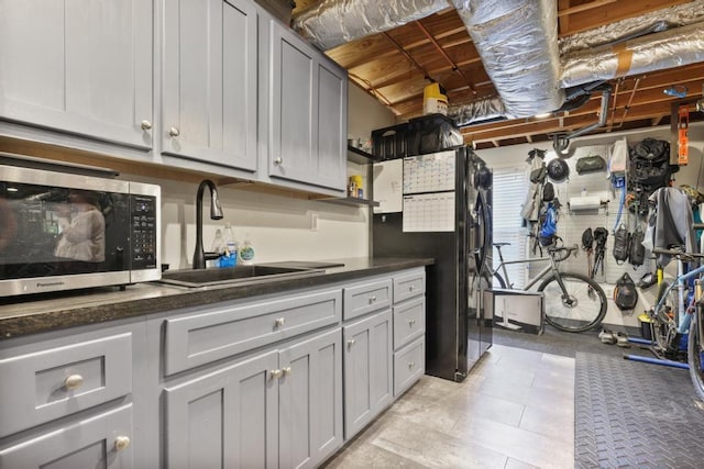 interior space featuring black fridge with ice dispenser and a sink