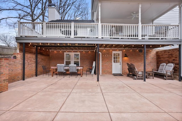 back of property with brick siding, a patio area, a chimney, and outdoor dining area