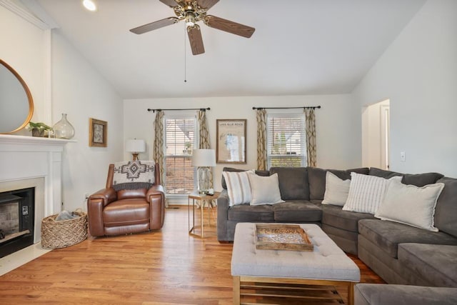 living area with a wealth of natural light, lofted ceiling, and light wood-style flooring