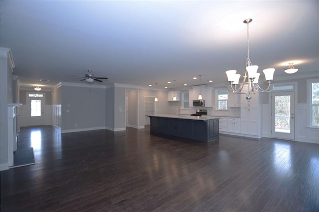 unfurnished living room featuring crown molding, sink, ceiling fan with notable chandelier, and dark hardwood / wood-style flooring