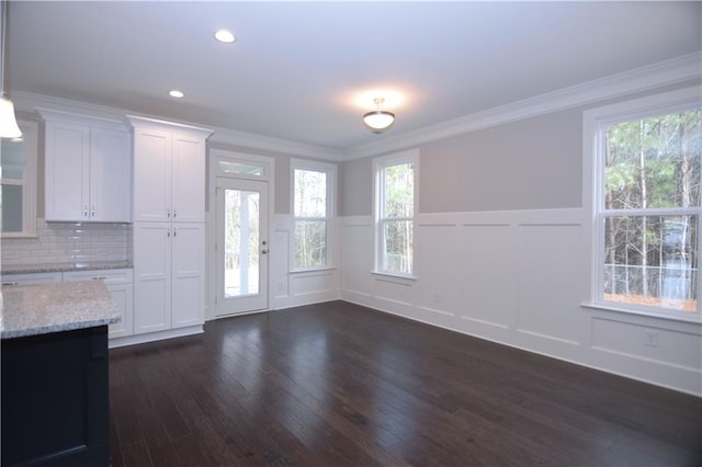 foyer entrance featuring ornamental molding, a wealth of natural light, and dark hardwood / wood-style flooring