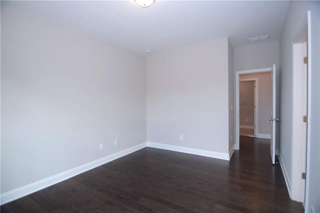 unfurnished room with dark wood-type flooring