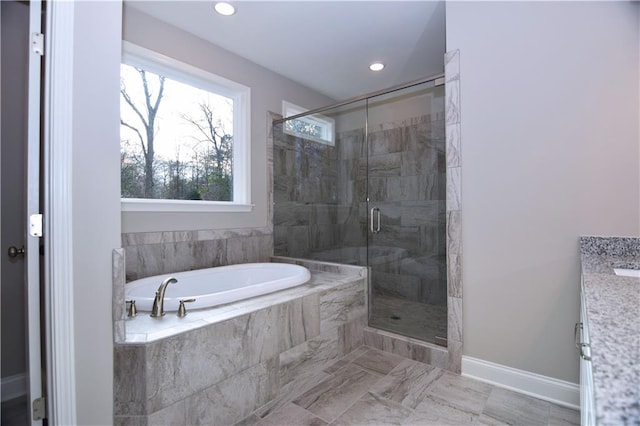 bathroom with vanity and shower with separate bathtub