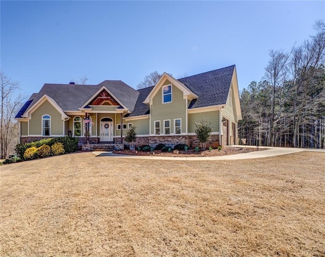 craftsman house with roof with shingles and a front lawn