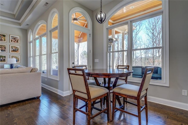 dining area featuring dark wood-type flooring, baseboards, visible vents, and ornamental molding