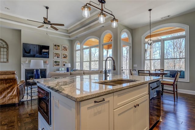 kitchen with built in microwave, open floor plan, dark wood finished floors, and a sink