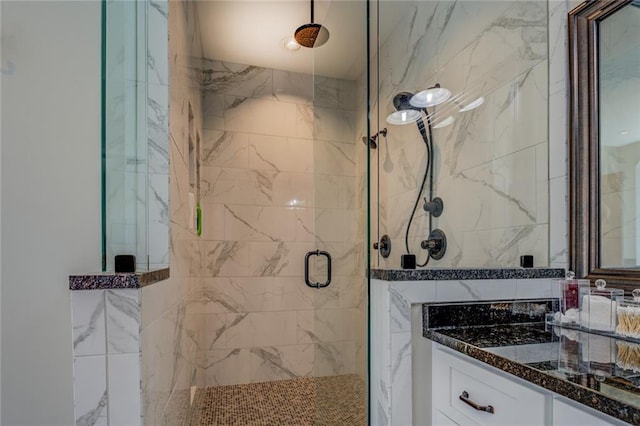 full bathroom featuring a marble finish shower, tile walls, and vanity