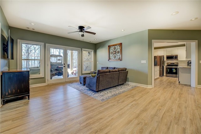 living room featuring french doors, baseboards, light wood-style floors, and ceiling fan