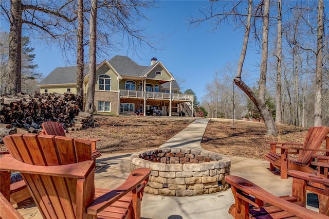 rear view of property with a wooden deck, a fire pit, stairway, and a patio area