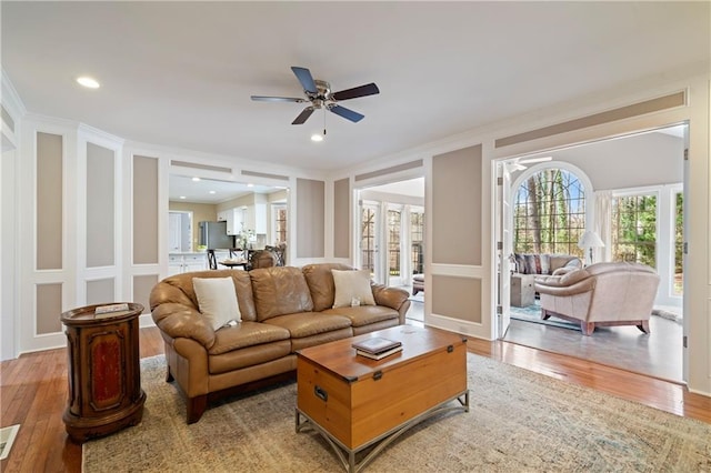 living room featuring french doors, visible vents, light wood-style flooring, and crown molding