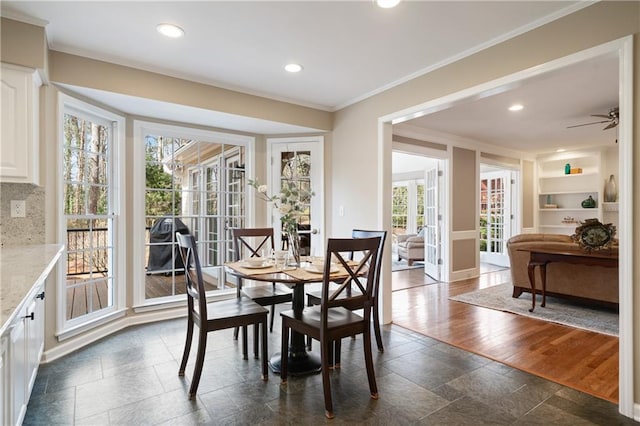 dining area with stone tile flooring, built in features, recessed lighting, and ornamental molding