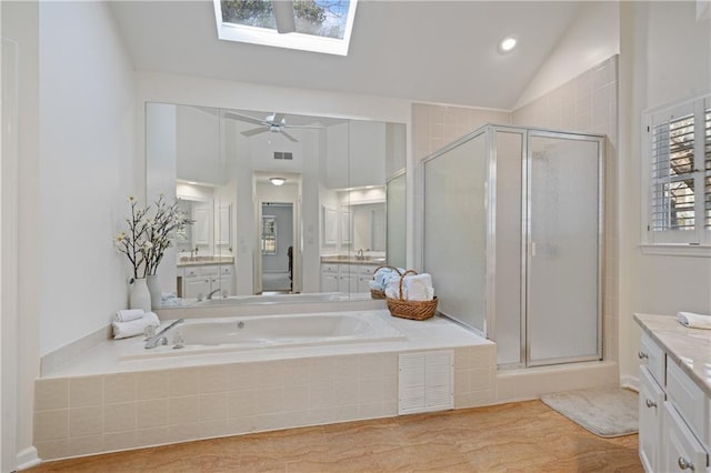 full bathroom with lofted ceiling with skylight, visible vents, a shower stall, and a garden tub