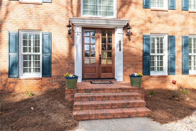 view of exterior entry with brick siding and french doors