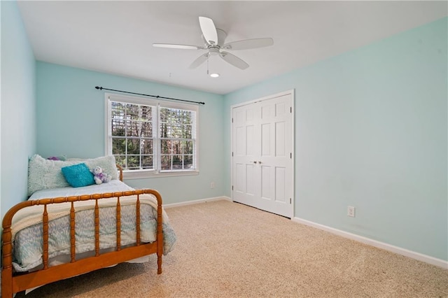 carpeted bedroom featuring a closet, a ceiling fan, and baseboards