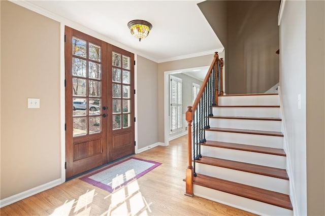 entrance foyer featuring baseboards, wood finished floors, stairs, and crown molding