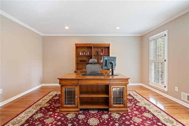 office space with baseboards, crown molding, and light wood-style floors