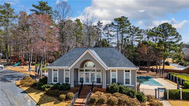 view of front of property with stucco siding, french doors, fence, and a shingled roof