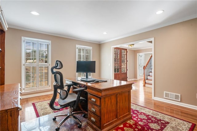 office space featuring crown molding, visible vents, and light wood finished floors