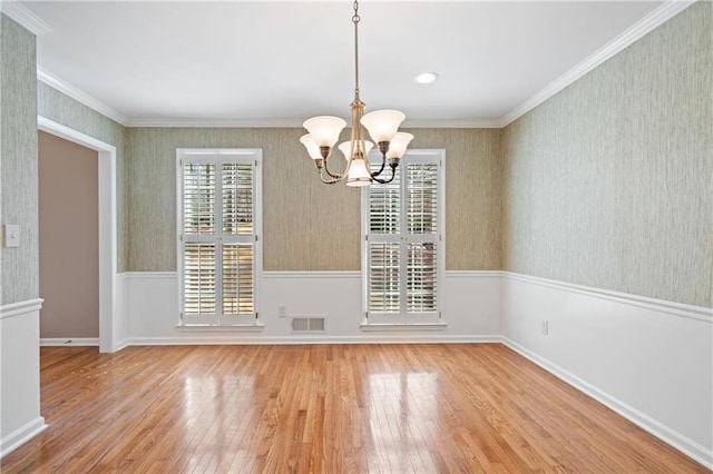 unfurnished dining area with wallpapered walls, crown molding, and visible vents