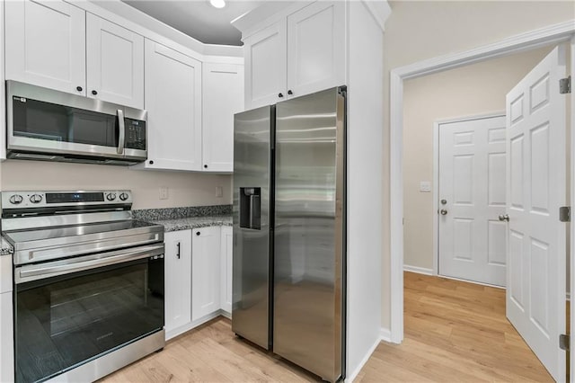 5232 W Mountain St, Stone Mountain, GA 30083 - kitchen with appliances with stainless steel finishes, light wood-type flooring, and white cabinetry