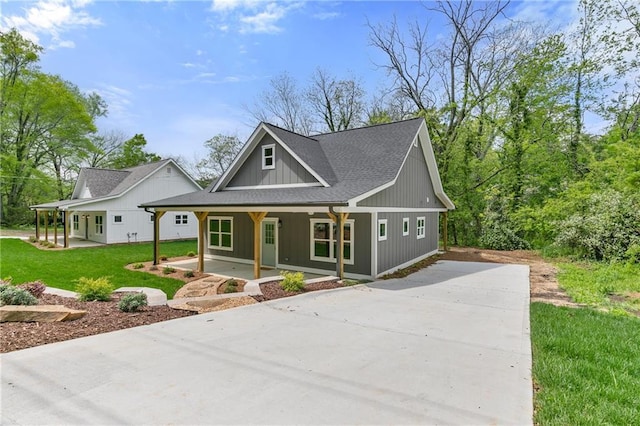 5232 W Mountain St, Stone Mountain, GA 30083 - modern farmhouse with concrete driveway, covered porch, a front lawn, and a shingled roof