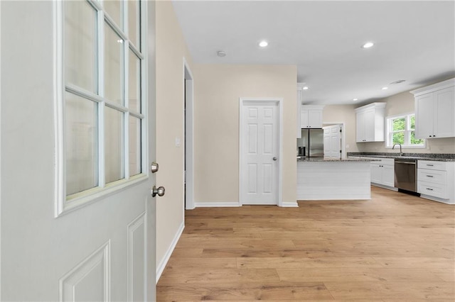 5232 W Mountain St, Stone Mountain, GA 30083 - kitchen with appliances with stainless steel finishes, white cabinets, light wood-type flooring, recessed lighting, and dark stone counters