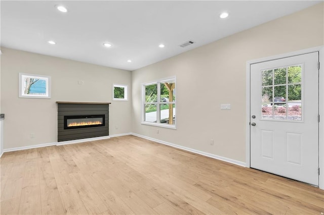 5232 W Mountain St, Stone Mountain, GA 30083 - unfurnished living room with healthy amount of natural light, light wood finished floors, a glass covered fireplace, and recessed lighting
