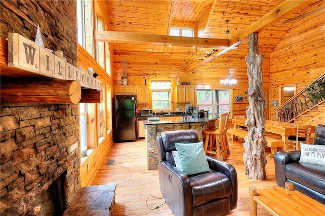 living room featuring lofted ceiling with beams, stairs, wood ceiling, light wood-style floors, and wooden walls