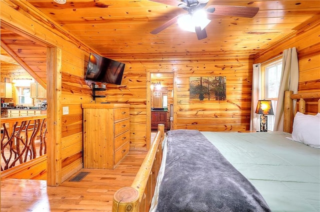 bedroom featuring wood walls, wood finished floors, visible vents, and wooden ceiling