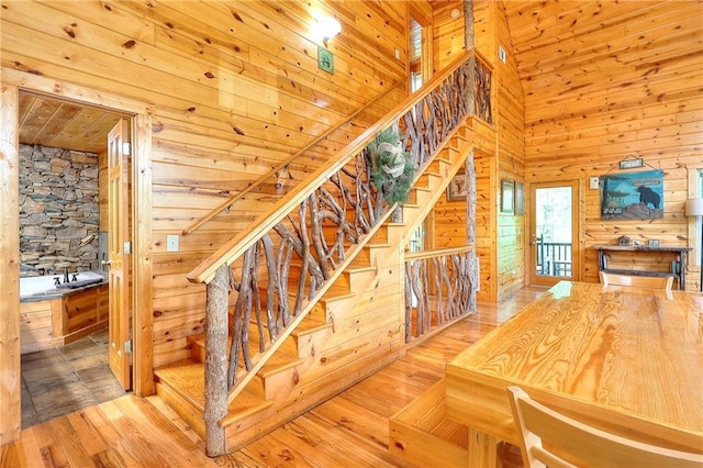 staircase featuring wooden walls, wood-type flooring, and wood ceiling