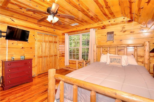 bedroom featuring wooden walls, wood finished floors, and wooden ceiling
