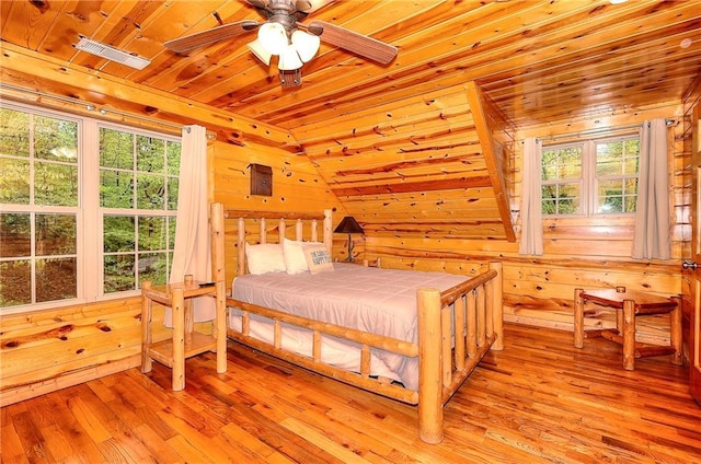bedroom featuring wooden ceiling, wood walls, and multiple windows