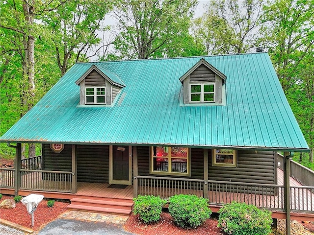 view of front of property with a porch, metal roof, and faux log siding