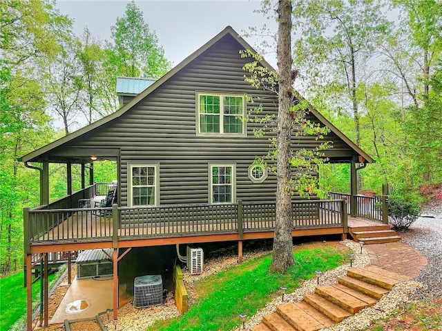 back of house with a deck, central AC, and log veneer siding