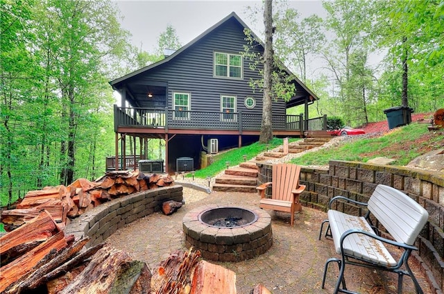 rear view of property featuring a deck, a fire pit, a patio, central AC unit, and stairs